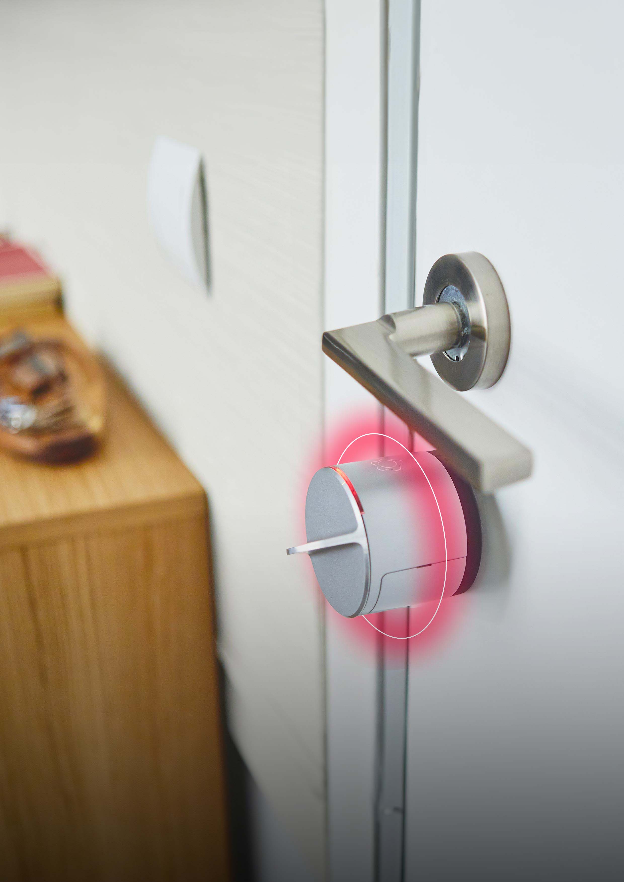 Smart door lock on handle with red alert light indicator.